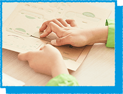 ダンボールをくりぬいている様子の写真